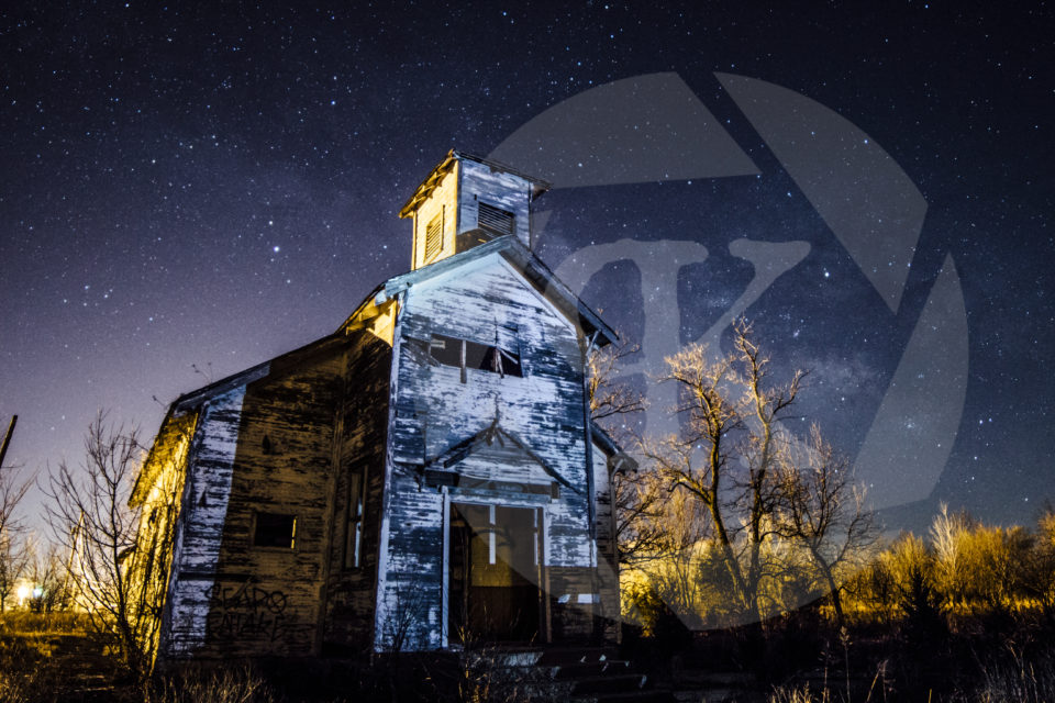 An old, abandoned chapel sits in Picher Oklahoma, illuminated by the night sky